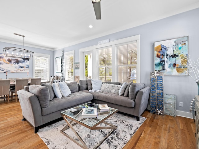 living room with ceiling fan with notable chandelier and wood-type flooring