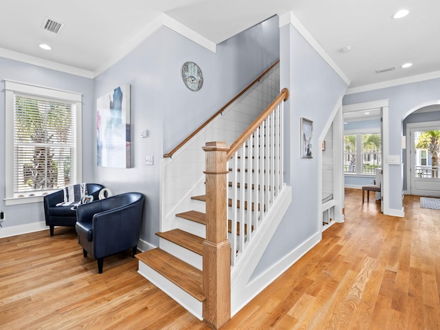 staircase featuring crown molding and wood-type flooring