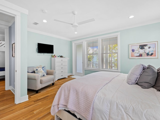 bedroom featuring light hardwood / wood-style floors, ceiling fan, and ornamental molding