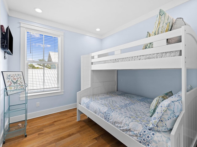 bedroom with crown molding and hardwood / wood-style floors