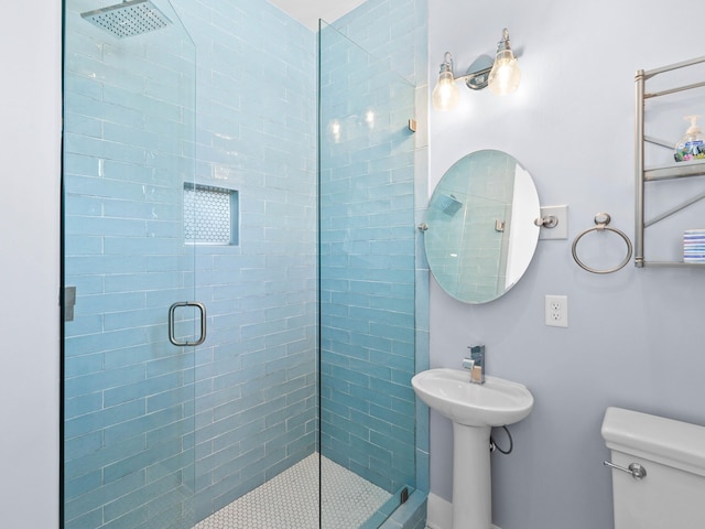 bathroom with sink, toilet, and a shower with shower door