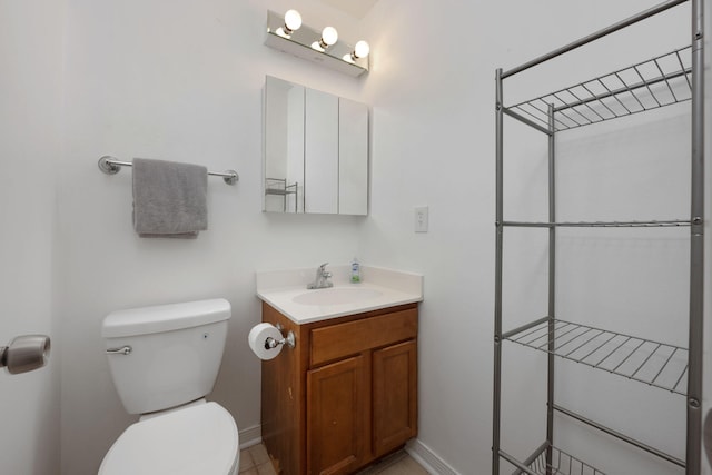 bathroom featuring vanity, toilet, and baseboards