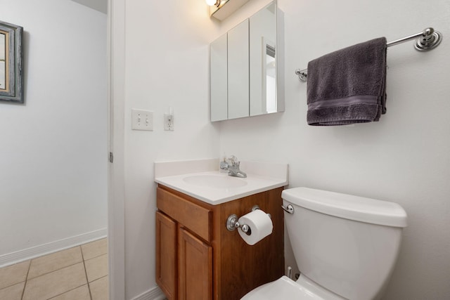 bathroom featuring baseboards, vanity, toilet, and tile patterned floors