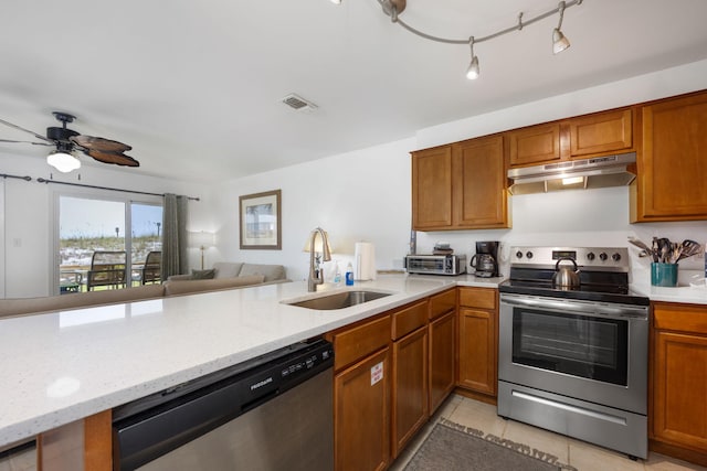 kitchen with open floor plan, a peninsula, stainless steel appliances, under cabinet range hood, and a sink