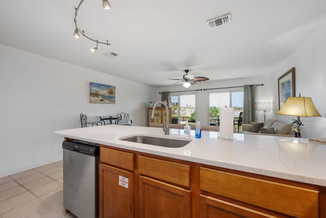 kitchen featuring visible vents, open floor plan, stainless steel dishwasher, a sink, and light tile patterned flooring