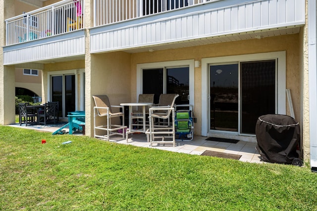 exterior space with a lawn, a patio, a balcony, and stucco siding