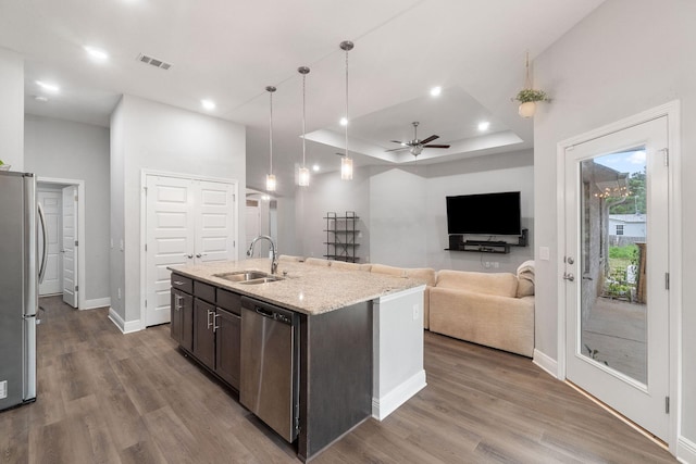 kitchen featuring dark brown cabinetry, visible vents, a tray ceiling, stainless steel appliances, and a sink