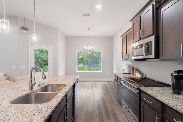 kitchen with visible vents, appliances with stainless steel finishes, wood finished floors, dark brown cabinets, and a sink