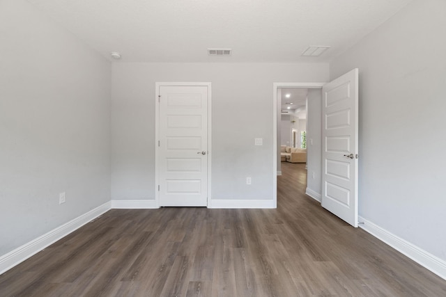 unfurnished bedroom featuring wood finished floors, visible vents, and baseboards