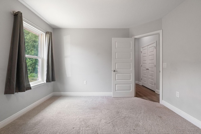 carpeted spare room featuring a wealth of natural light and baseboards