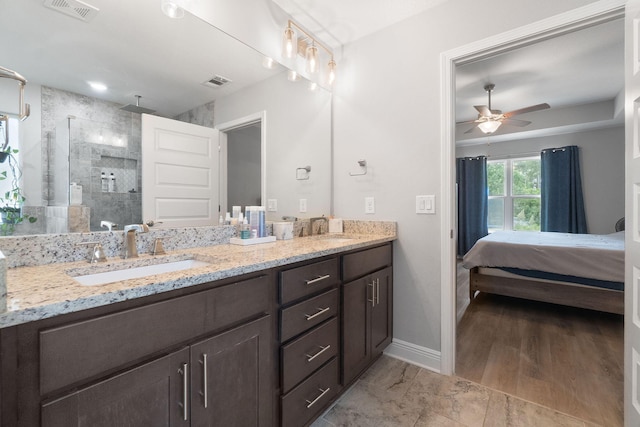 full bathroom with visible vents, a sink, and tiled shower