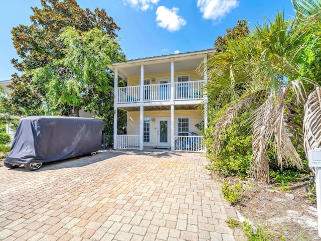 back of property with a balcony and covered porch