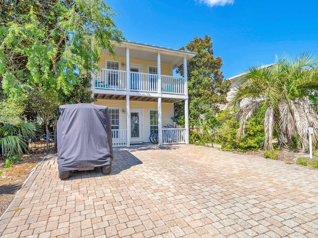 rear view of property with fence and a balcony