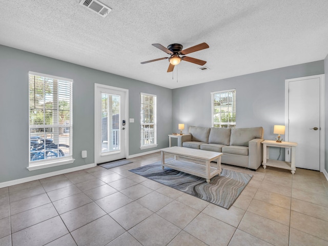 living room featuring light tile patterned floors, ceiling fan, and visible vents