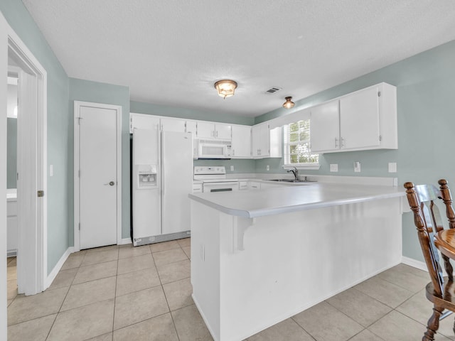 kitchen featuring a peninsula, white appliances, white cabinets, and light countertops