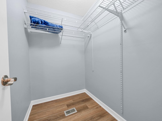 walk in closet with visible vents and wood finished floors