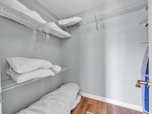 walk in closet with wood finished floors