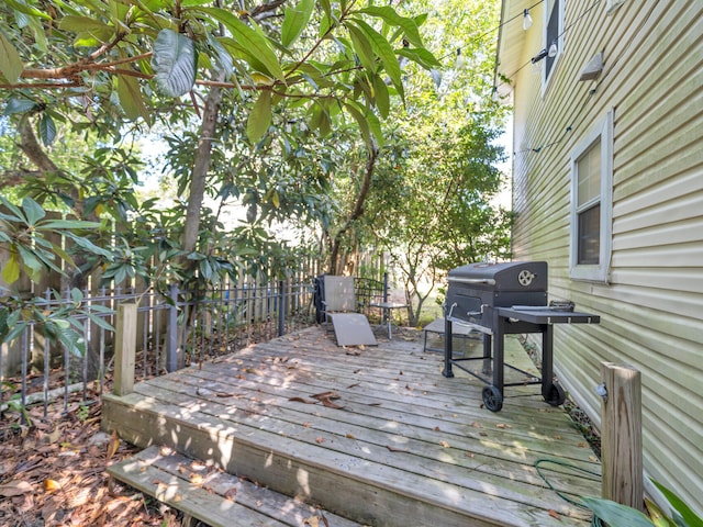 wooden deck with a grill and fence