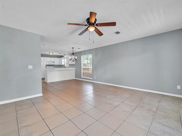 unfurnished living room with ceiling fan with notable chandelier, light tile patterned flooring, visible vents, and baseboards