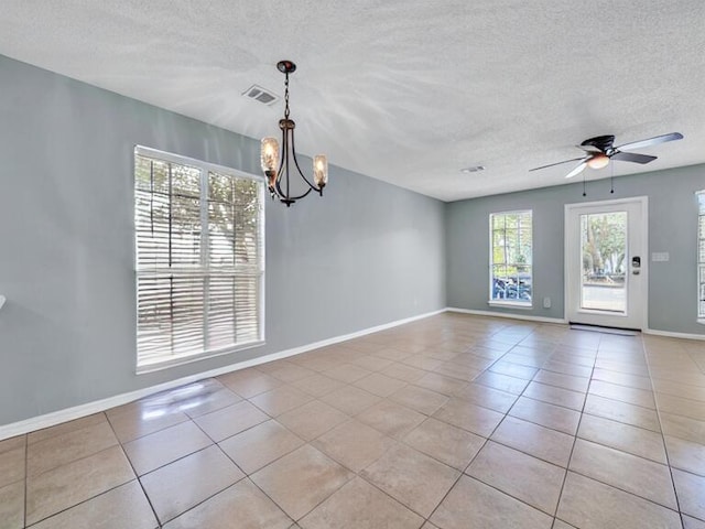 spare room featuring a textured ceiling, baseboards, and light tile patterned floors