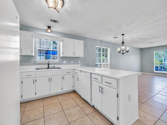 kitchen with decorative light fixtures, white appliances, light countertops, and visible vents