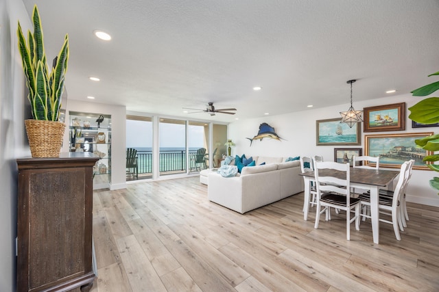 living room with light wood finished floors, a ceiling fan, and recessed lighting