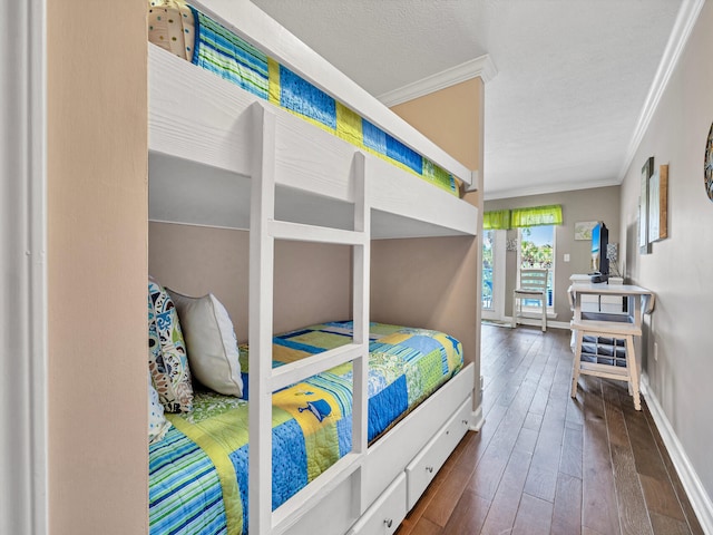 bedroom with dark wood-style floors, ornamental molding, a textured ceiling, and baseboards