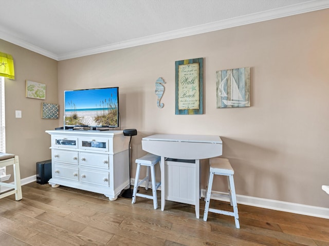 rec room featuring light wood-type flooring, crown molding, and baseboards