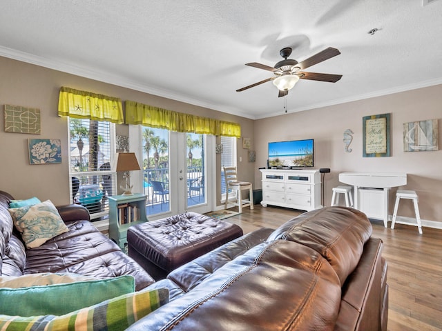 living room with dark wood-style floors, crown molding, a textured ceiling, and ceiling fan