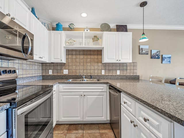 kitchen featuring appliances with stainless steel finishes, white cabinetry, a sink, and decorative light fixtures