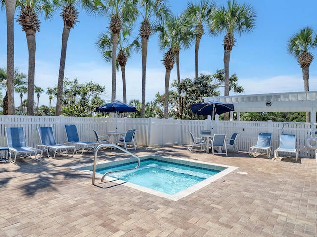 view of pool with a patio area, fence, and a community hot tub