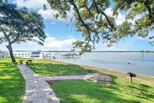 view of property's community featuring a yard, a boat dock, and a water view