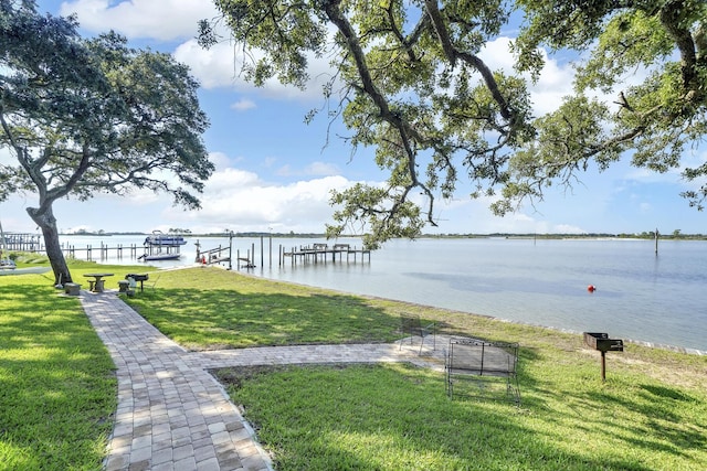 dock area with a lawn and a water view