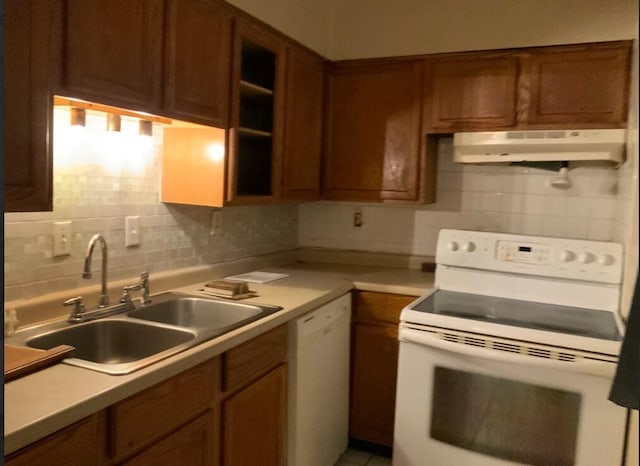 kitchen featuring sink, decorative backsplash, and white appliances