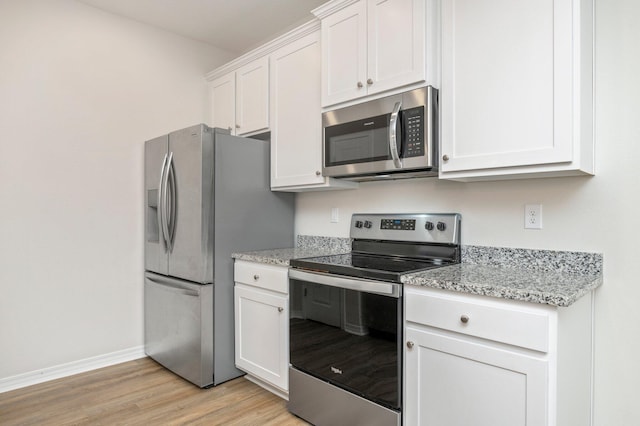 kitchen featuring appliances with stainless steel finishes, light hardwood / wood-style floors, white cabinetry, and light stone countertops