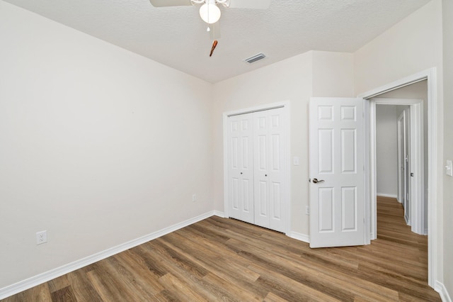 unfurnished bedroom with ceiling fan, hardwood / wood-style flooring, and a closet