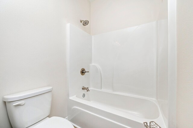 bathroom featuring washtub / shower combination and toilet