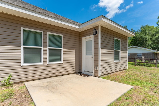 property entrance with a patio and a lawn