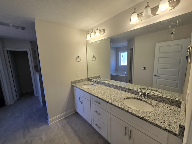 bathroom with vanity, a textured ceiling, and a bathing tub