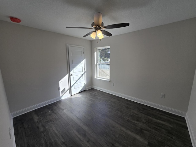 unfurnished room featuring dark hardwood / wood-style flooring, ceiling fan, and a textured ceiling