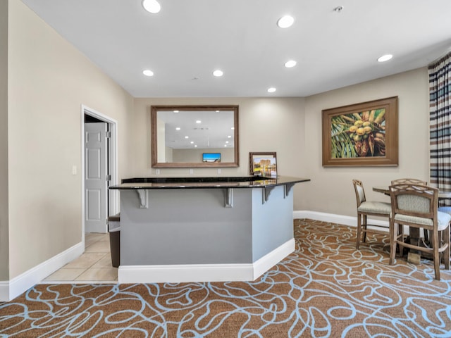 kitchen featuring baseboards, a breakfast bar area, and recessed lighting