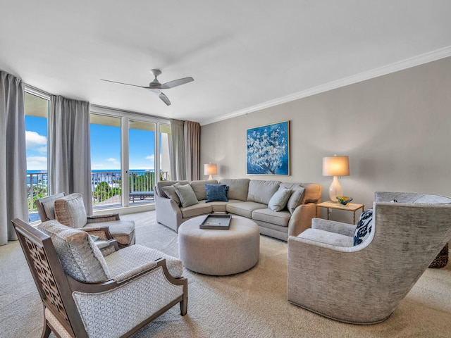 carpeted living area with a ceiling fan and crown molding