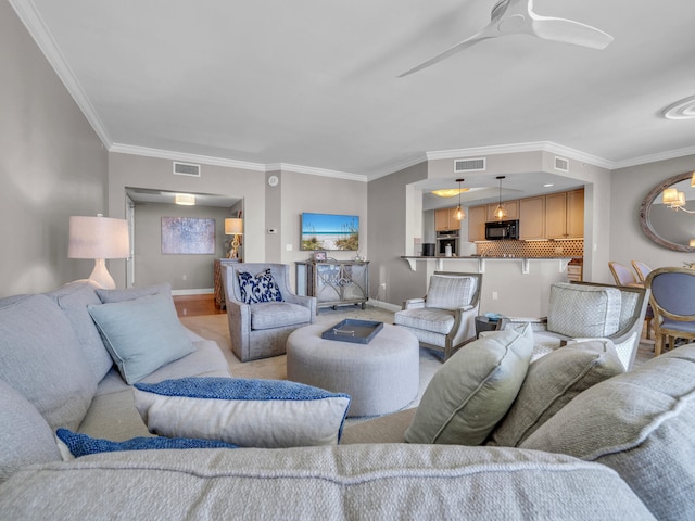 living area featuring baseboards, visible vents, and a ceiling fan