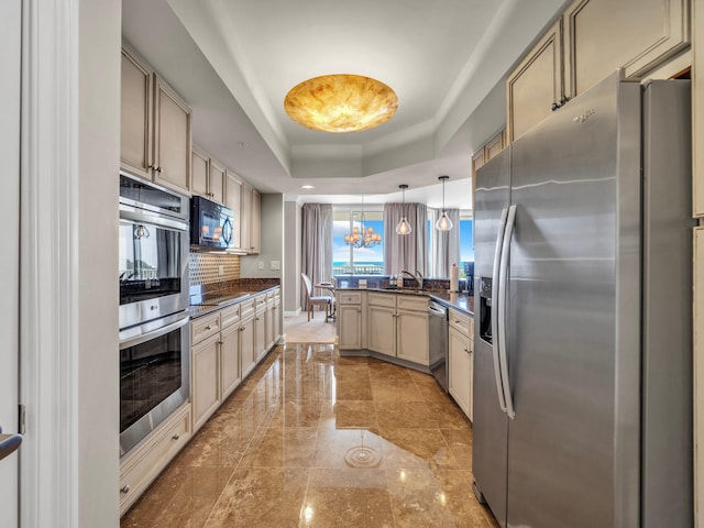 kitchen with dark countertops, a raised ceiling, a peninsula, and black appliances