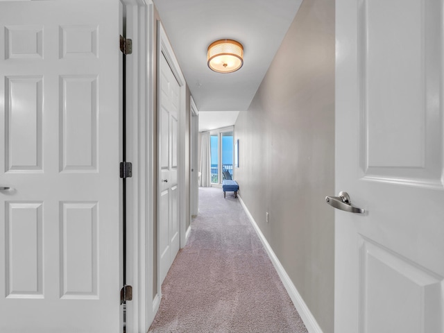 corridor featuring carpet flooring and baseboards