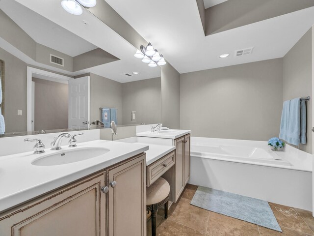 bathroom featuring two vanities, visible vents, a sink, and a bath