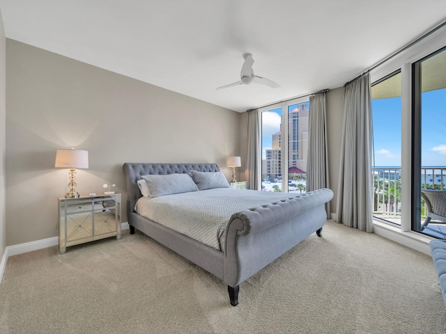 carpeted bedroom featuring a view of city, a ceiling fan, and baseboards