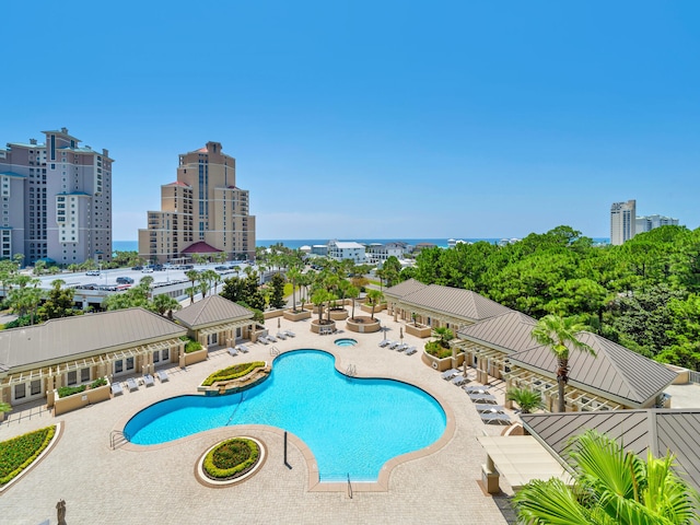 pool featuring a patio, fence, and a city view