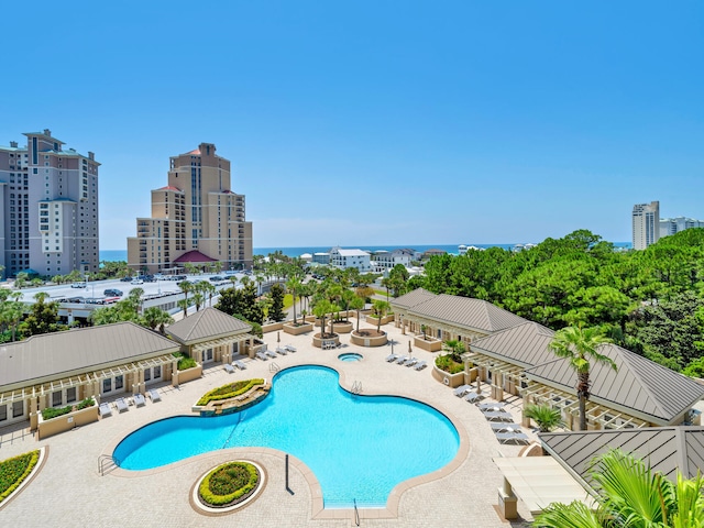 community pool with a view of city and a patio area