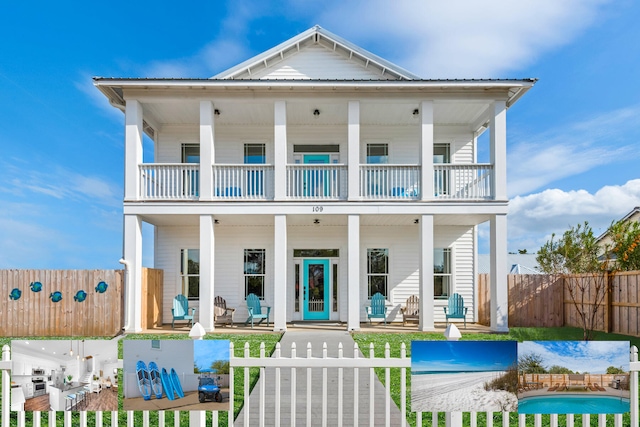 view of front of property with a balcony, metal roof, a porch, and fence private yard